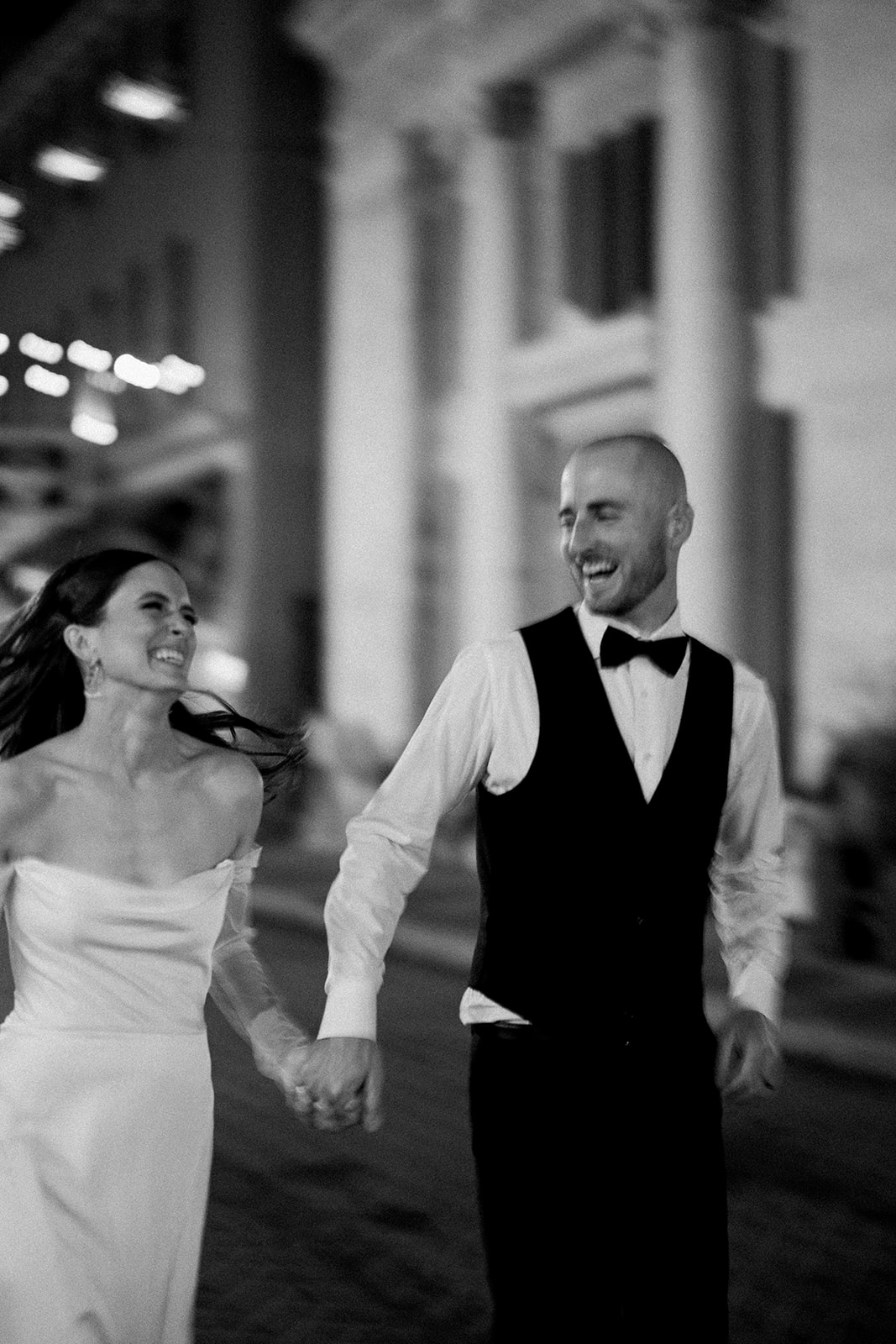 Candid black and white photo of a bride and groom laughing together during their wedding reception in Geneva, NY.