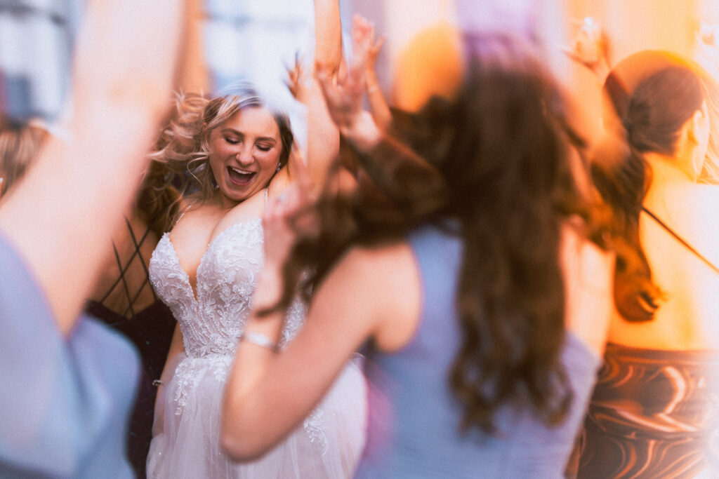 Rochester wedding photographer capturing a candid, high-energy dance floor moment with motion blur.